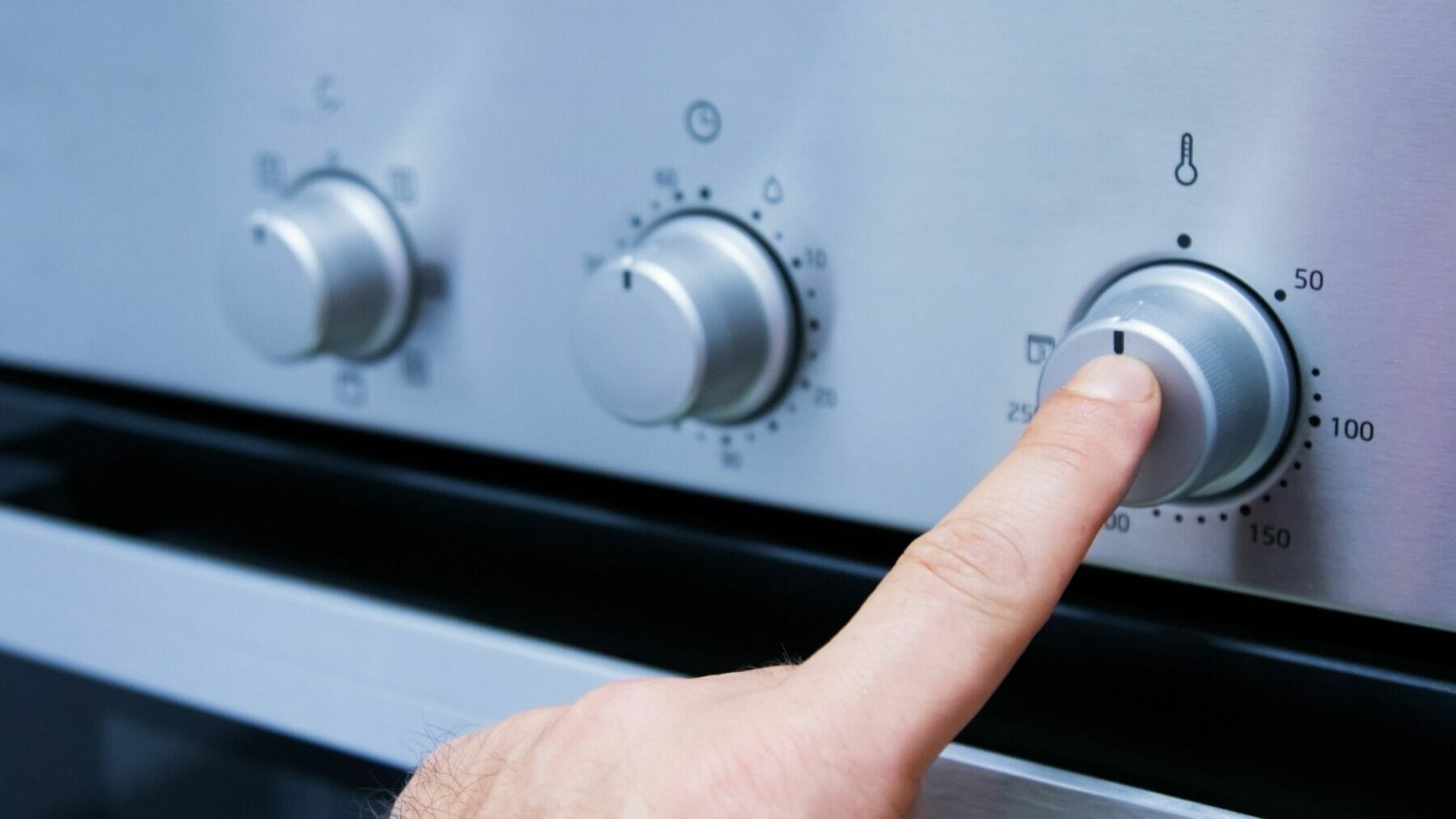 Finger pushing energy efficient stove nob.